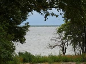 Lake Texoma framed by trees and plants seen from a roadend in Preston Bend, Texas